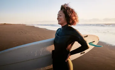 woman surfing in wetsuit in winter