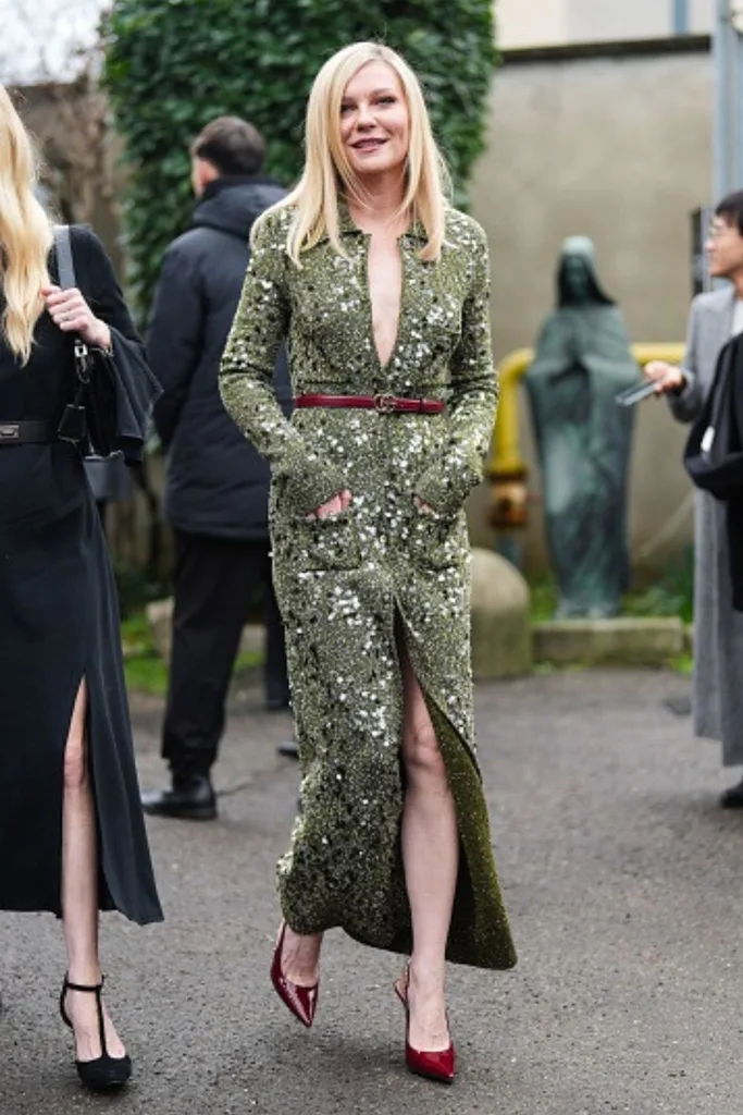 Image of Kirsten Dunst wearing a green, sequinned Gucci knit dress and belt