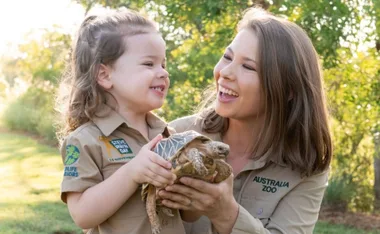 Bindi Irwin holds a turtle smiling at her daughter, revealing her secret tattoo