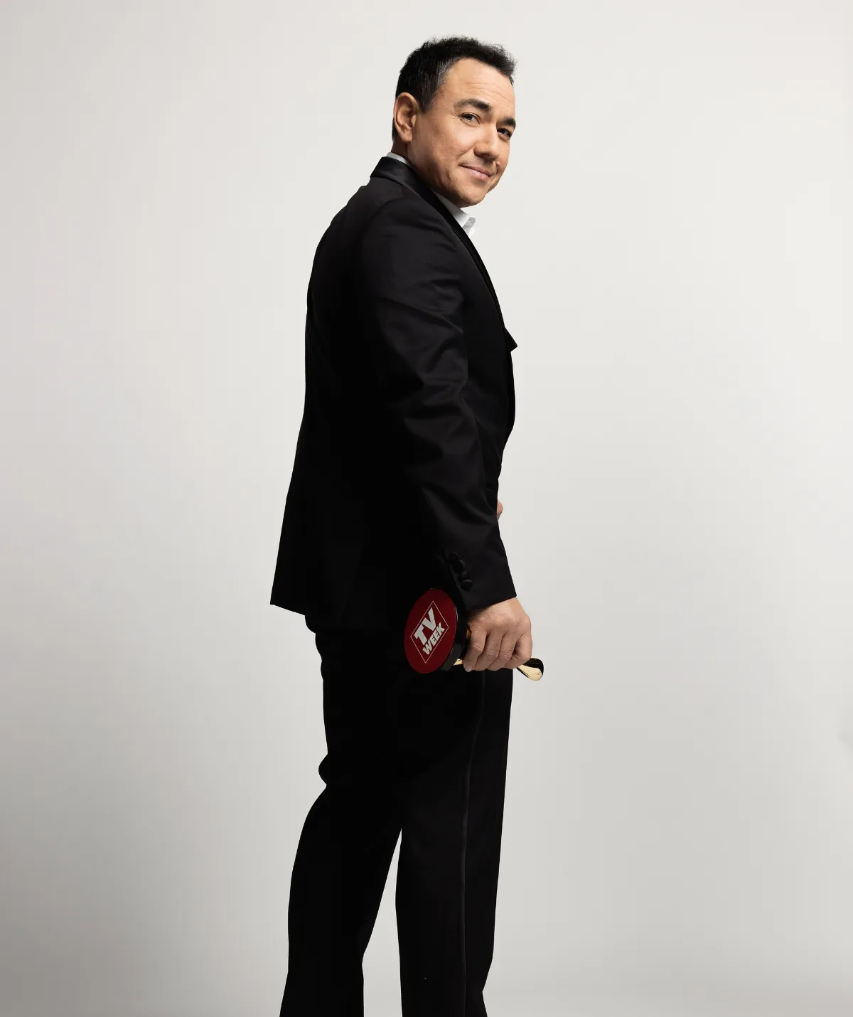 Sam Pang wears an all black suit