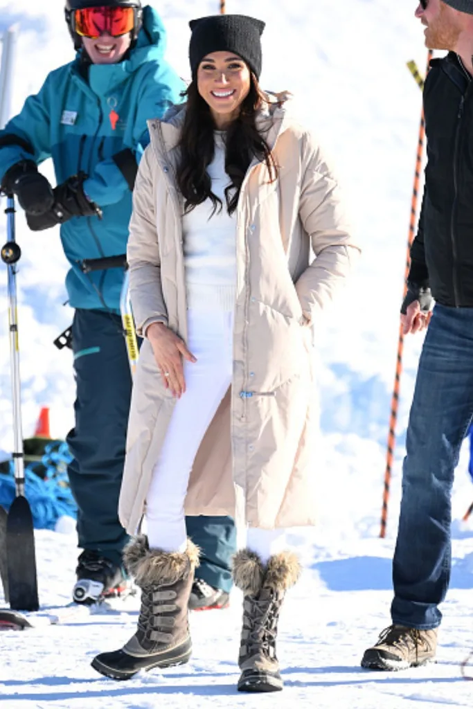 Meghan Markle wearing a puffer coat on the snow while skiing