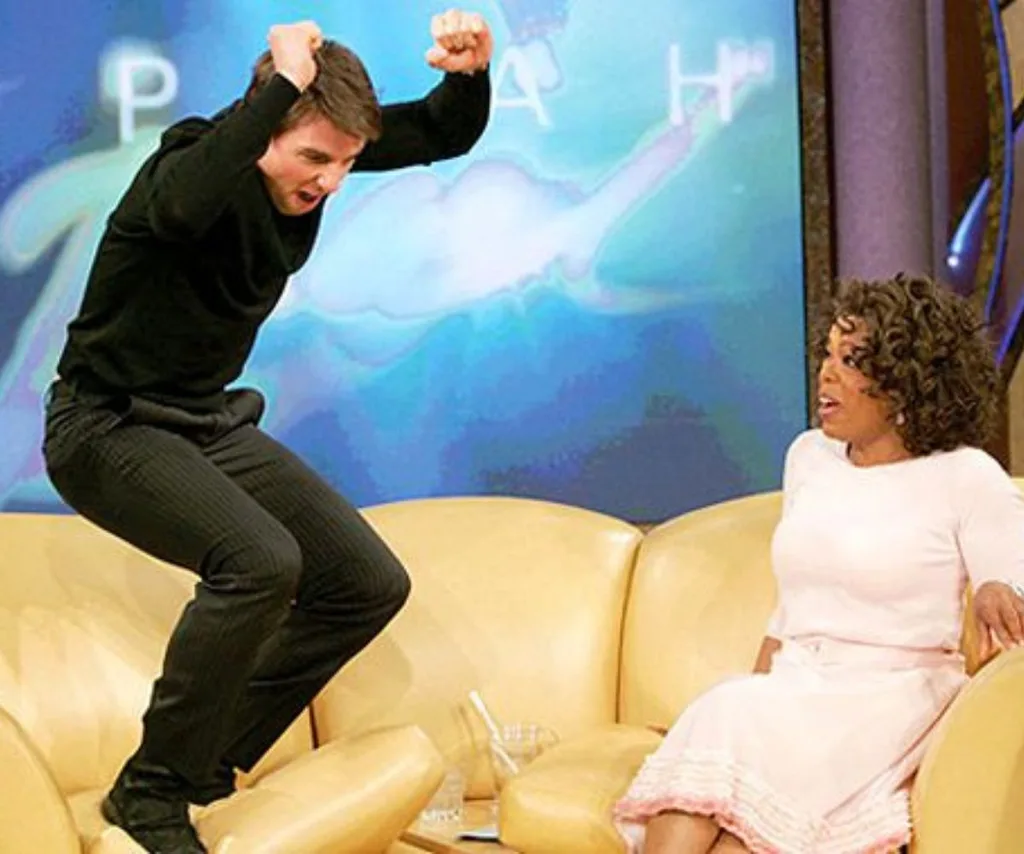 Tom Cruise jumps on Oprah's yellow sofa with Oprah looking in disbelief