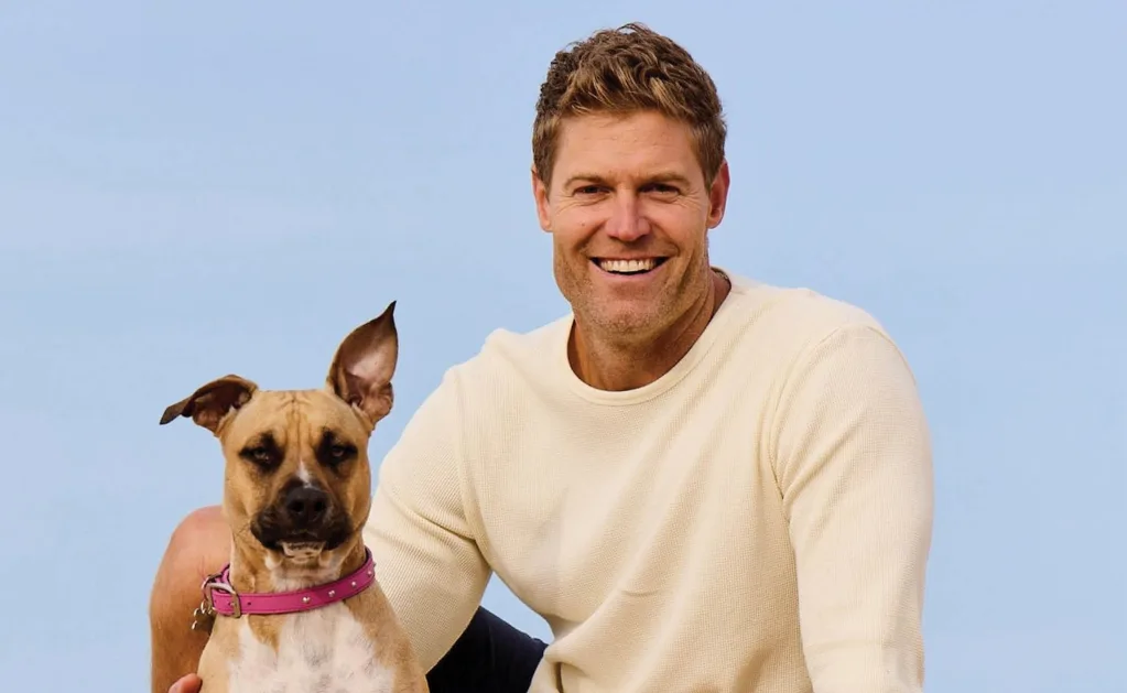 Dr chris in a white sweater with a dog