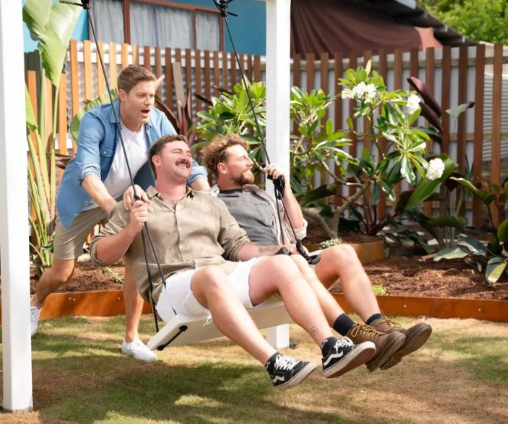 Dr Chris pushes Liam and Rhys on an outdoor swing