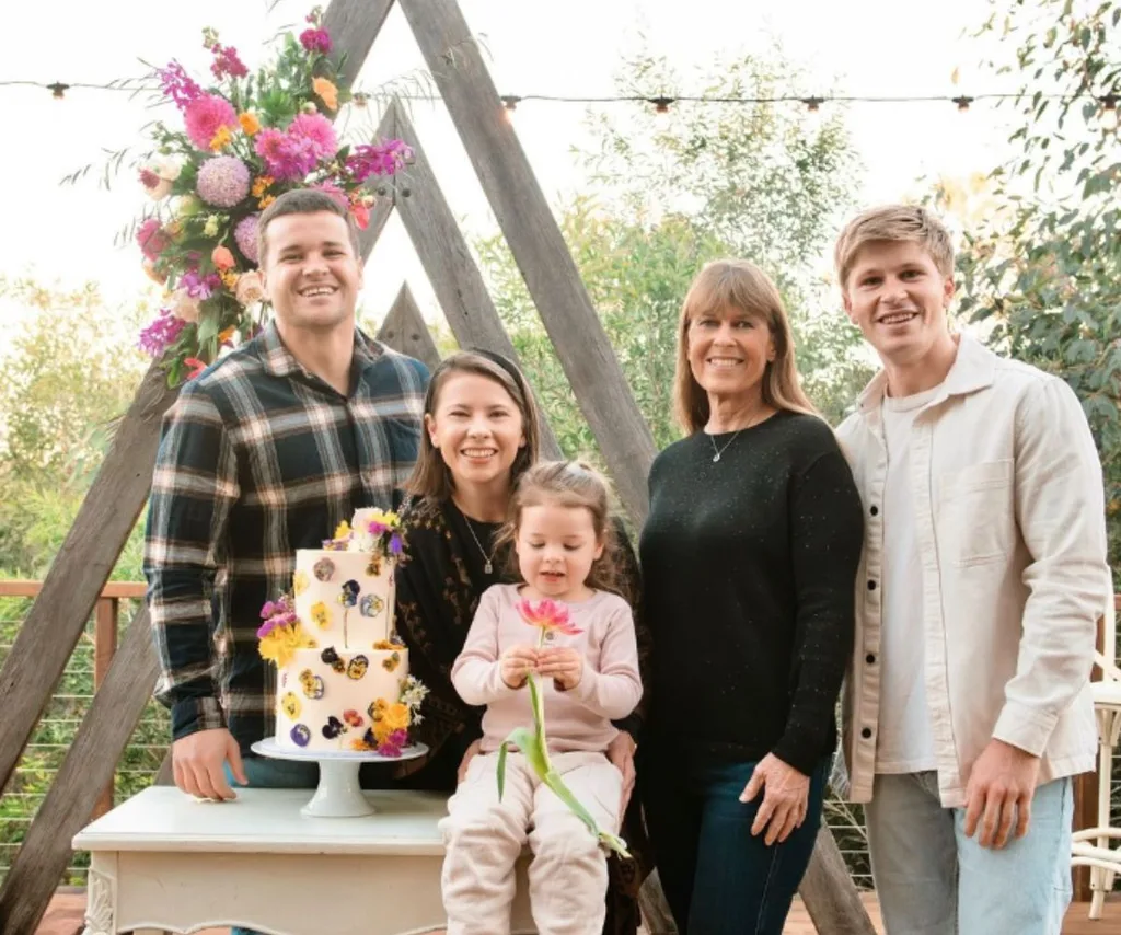 The Irwin family smile around a cake for Terri and Bindi's birthday