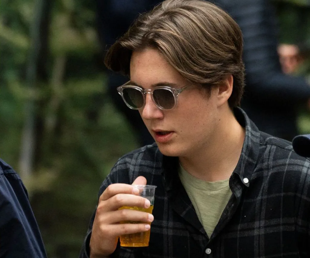 Prince Christian with a drink in hand, wearing flannel