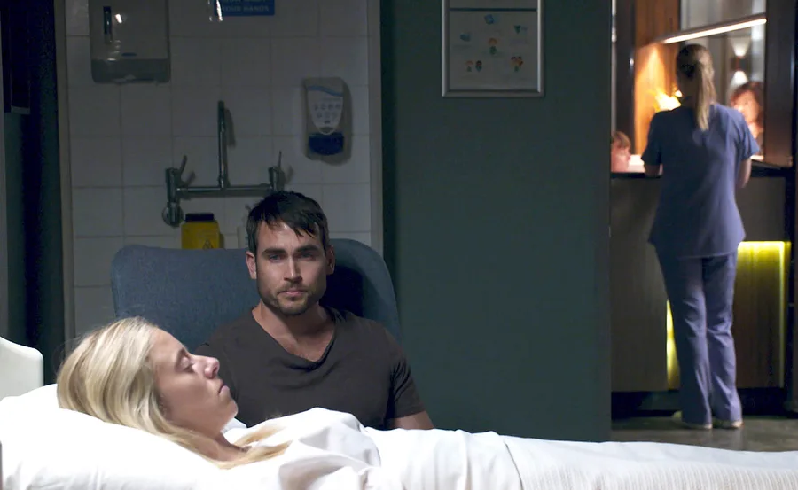 Cash sits beside Felicity in the hospital