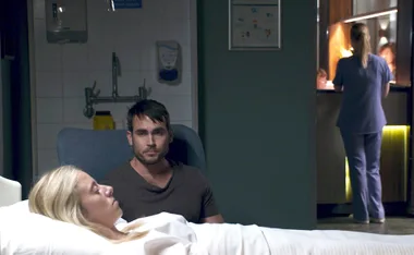 Cash sits beside Felicity in the hospital