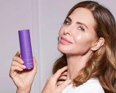 Trinny holding a bottle of Elevator skincare