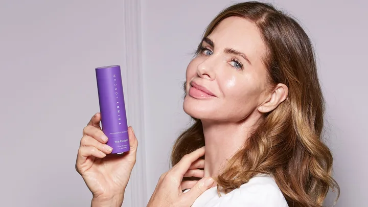 Trinny holding a bottle of Elevator skincare