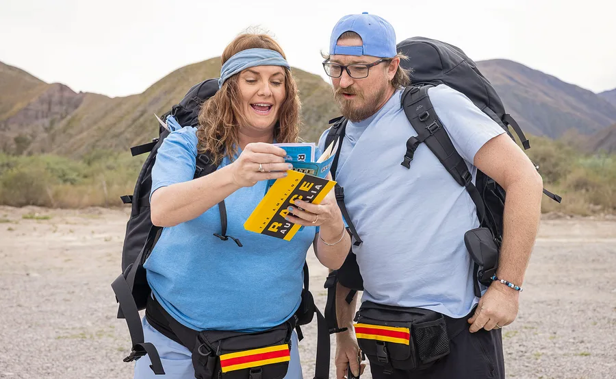 Brooke McClymont reads a clue to her husband Adam Eckersley, as the two compete in The Amazing Race.