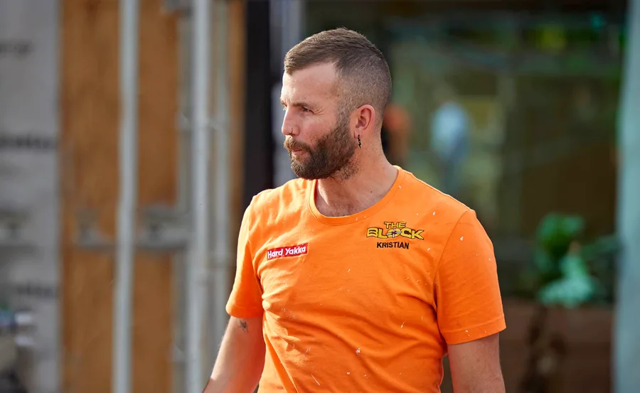 Kristian in an orange site t-shirt looking stressed walking through the site