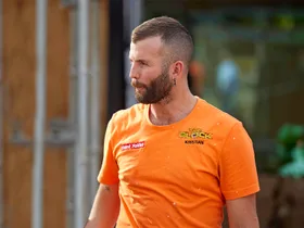 Kristian in an orange site t-shirt looking stressed walking through the site