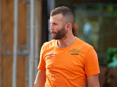 Kristian in an orange site t-shirt looking stressed walking through the site