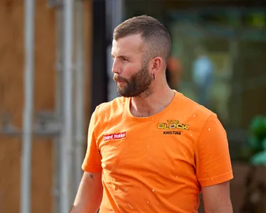 Kristian in an orange site t-shirt looking stressed walking through the site