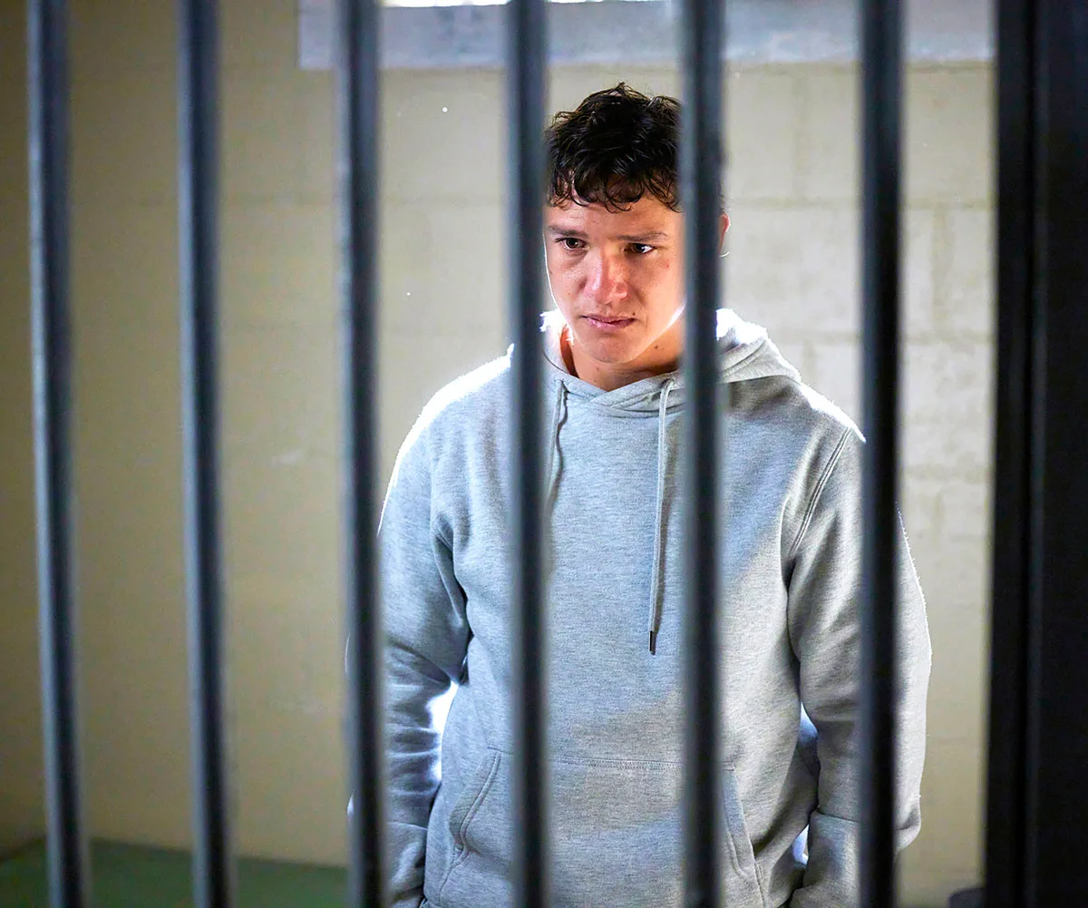 Perri stands behind bars as he is charged with the murder of his father.