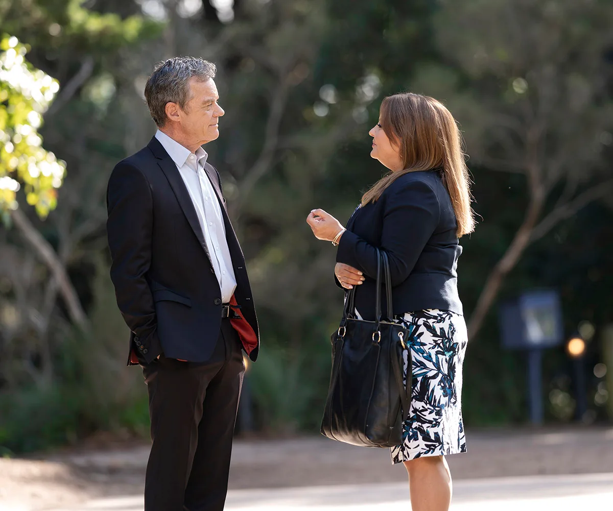 Paul and Terese standing in a park facing each other talking