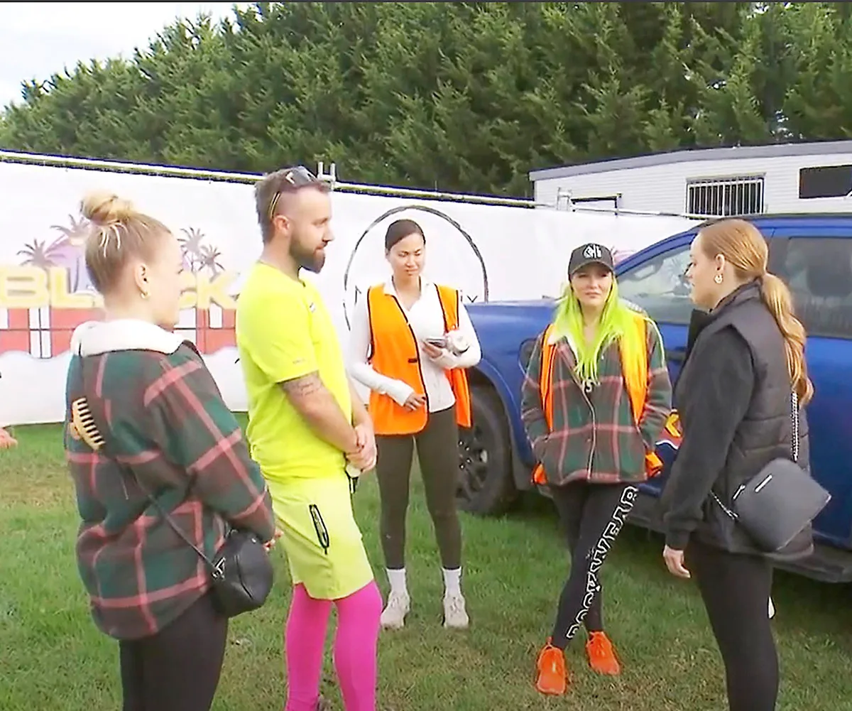 Charlotte, Haydn, Mimi, Kylie and Maddy all in a circle on green grass near a blue Ford ute discussing the video