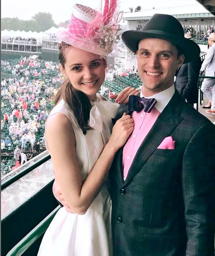 Jesse Spencer, in a hat and suit, posing next to his wife, Dr Kali Woodruff Carr.