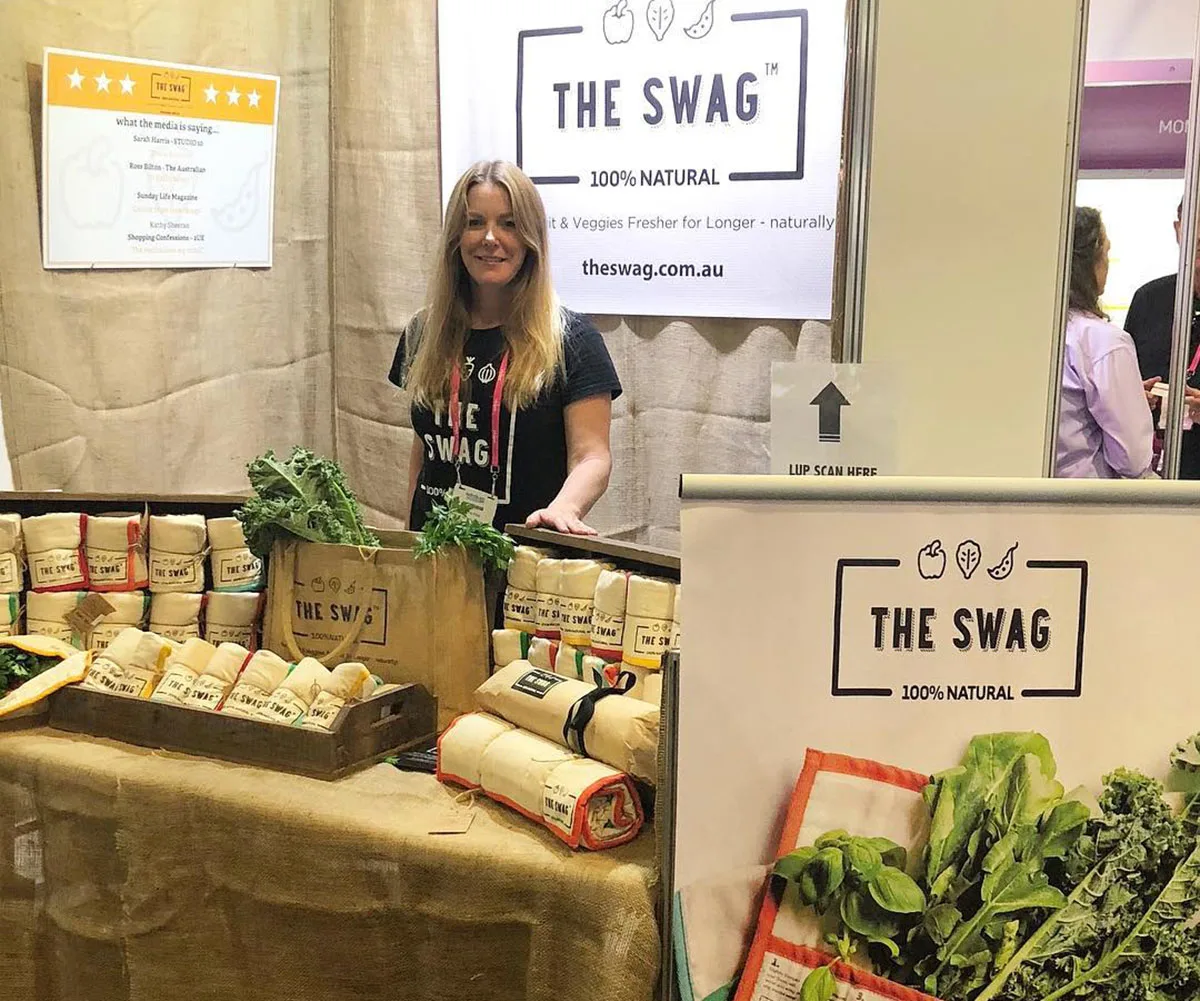 Peita, who created a tea towel-like product to save others thousands, stands at a stall promoting her product, called The Swag