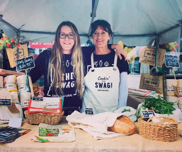 Peita and sister at market stall selling The Swag