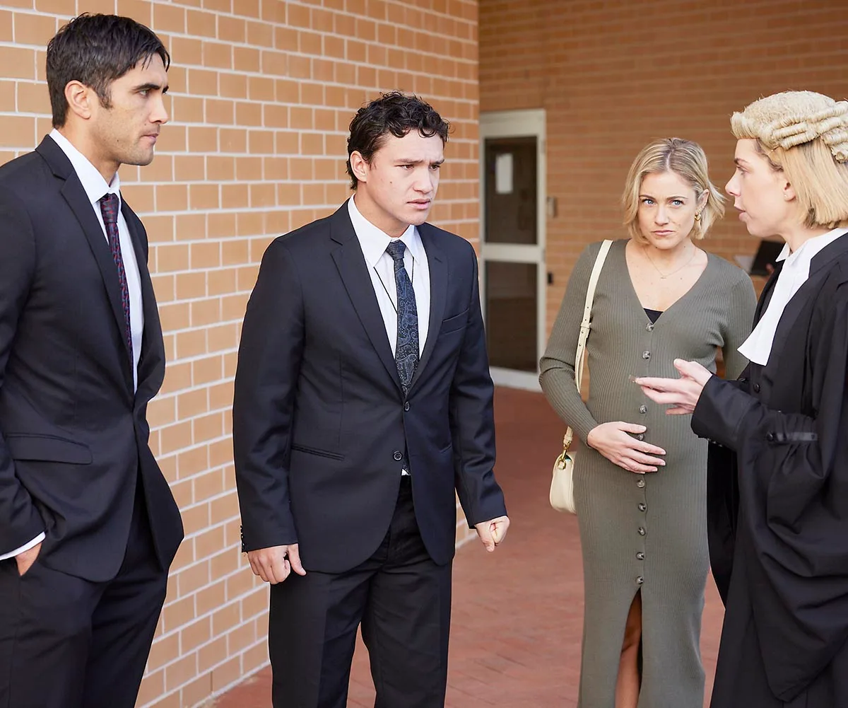 Tane, Harper and a lawyer stands with Perri outside court.