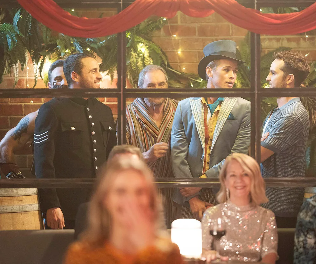 Aaron, Andrew, Karl, Byron and Rhett all prepare for the Boylesque performance behind a glass window in costume