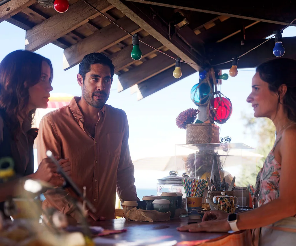 Tai Hara and Anna Samson talk with a bartender in a still from the season finale of Return to Paradise.