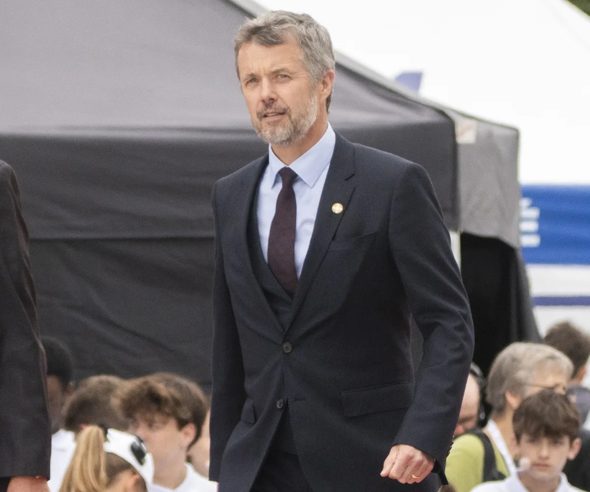 King Frederik standing and wearing a suit and tie.