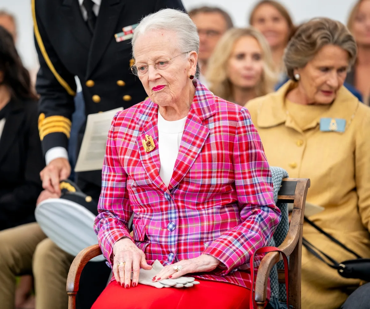 Queen Margrethe seated and wearing a pink jacket.