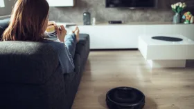 woman relaxing while a robot vacuum cleans