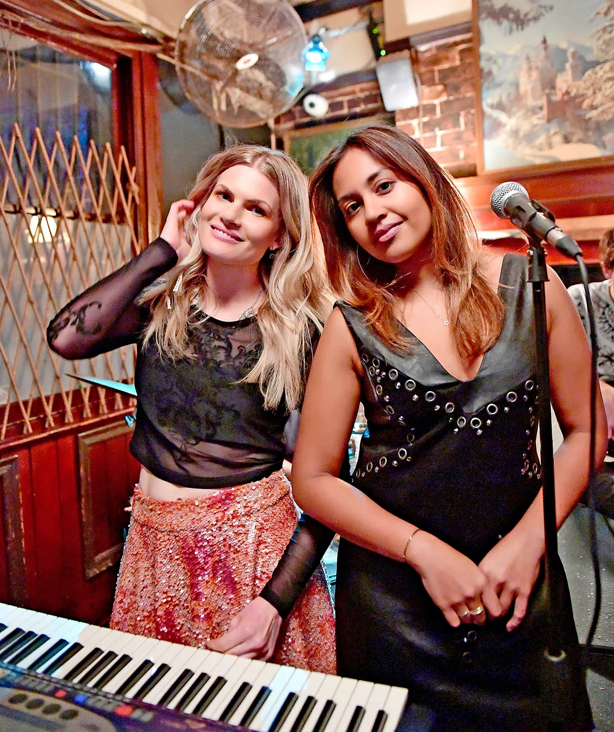 Bonnie Sveen, as Layla, and Jessica Mauboy, as Billie, stand in front of a microphone and keyboard in The Secret Daughter.