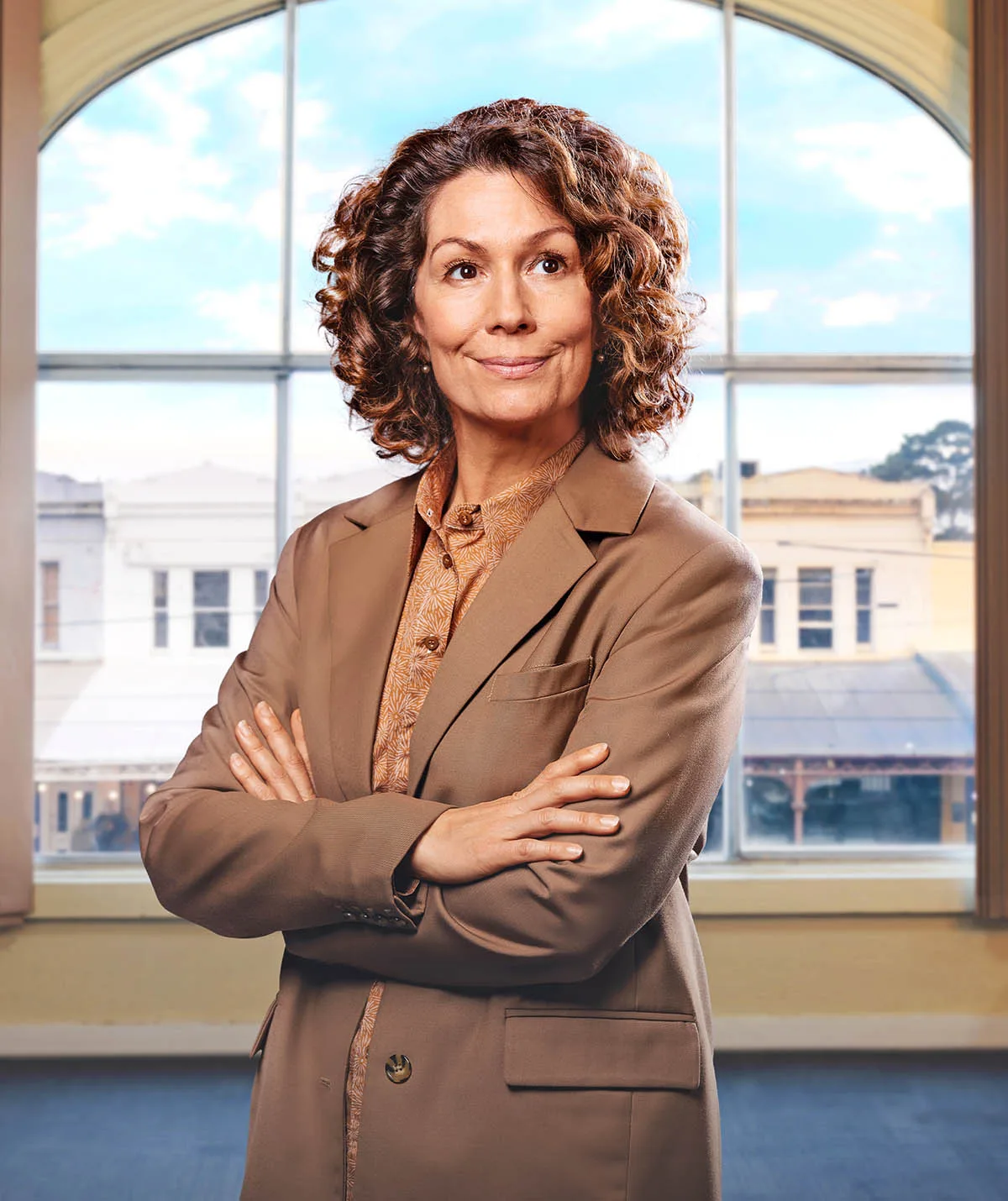 Kitty stands in her signature brown suit in a promo image for the third season of ABC comedy Fisk.