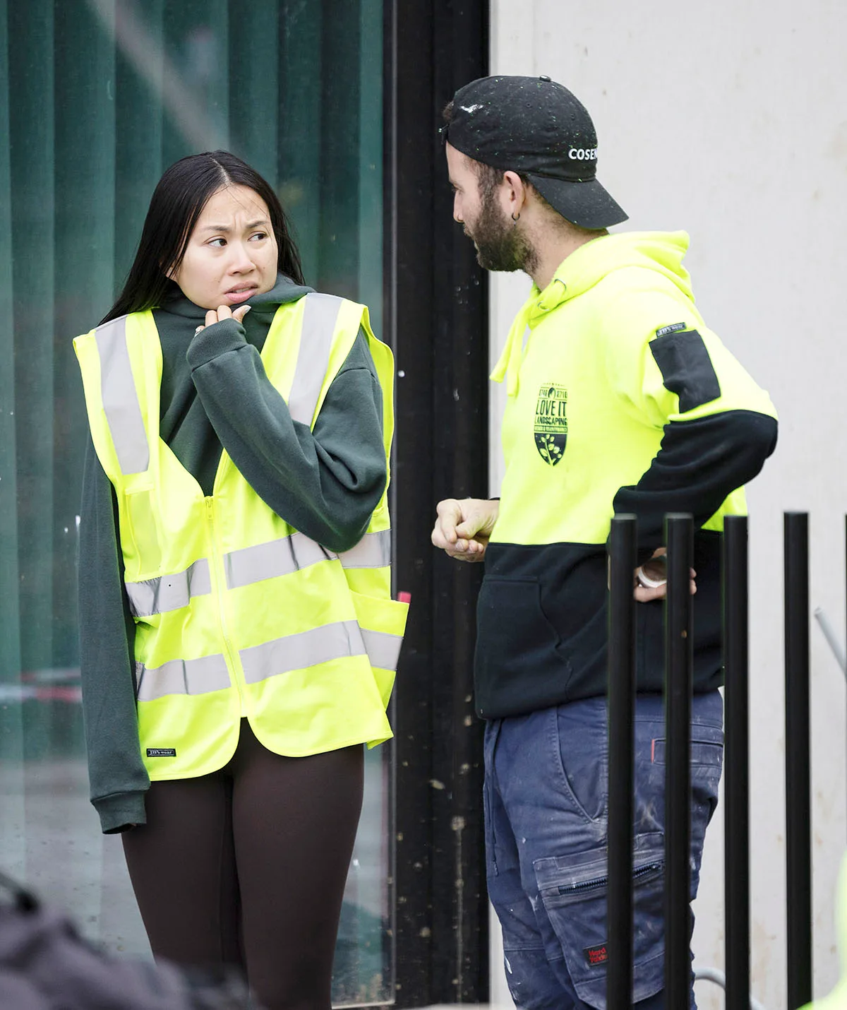 Mimi and Kristian rugged up in yellow hi vis looking very stressed on site