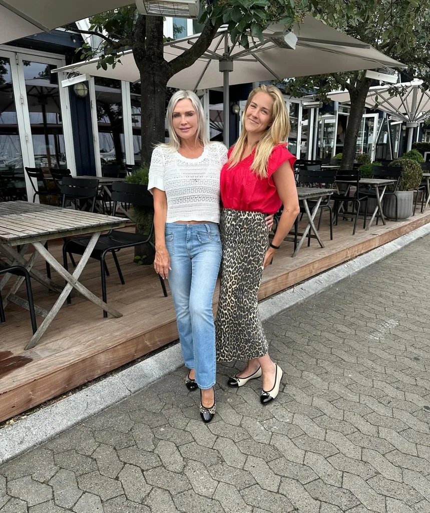 Two women pose smiling.