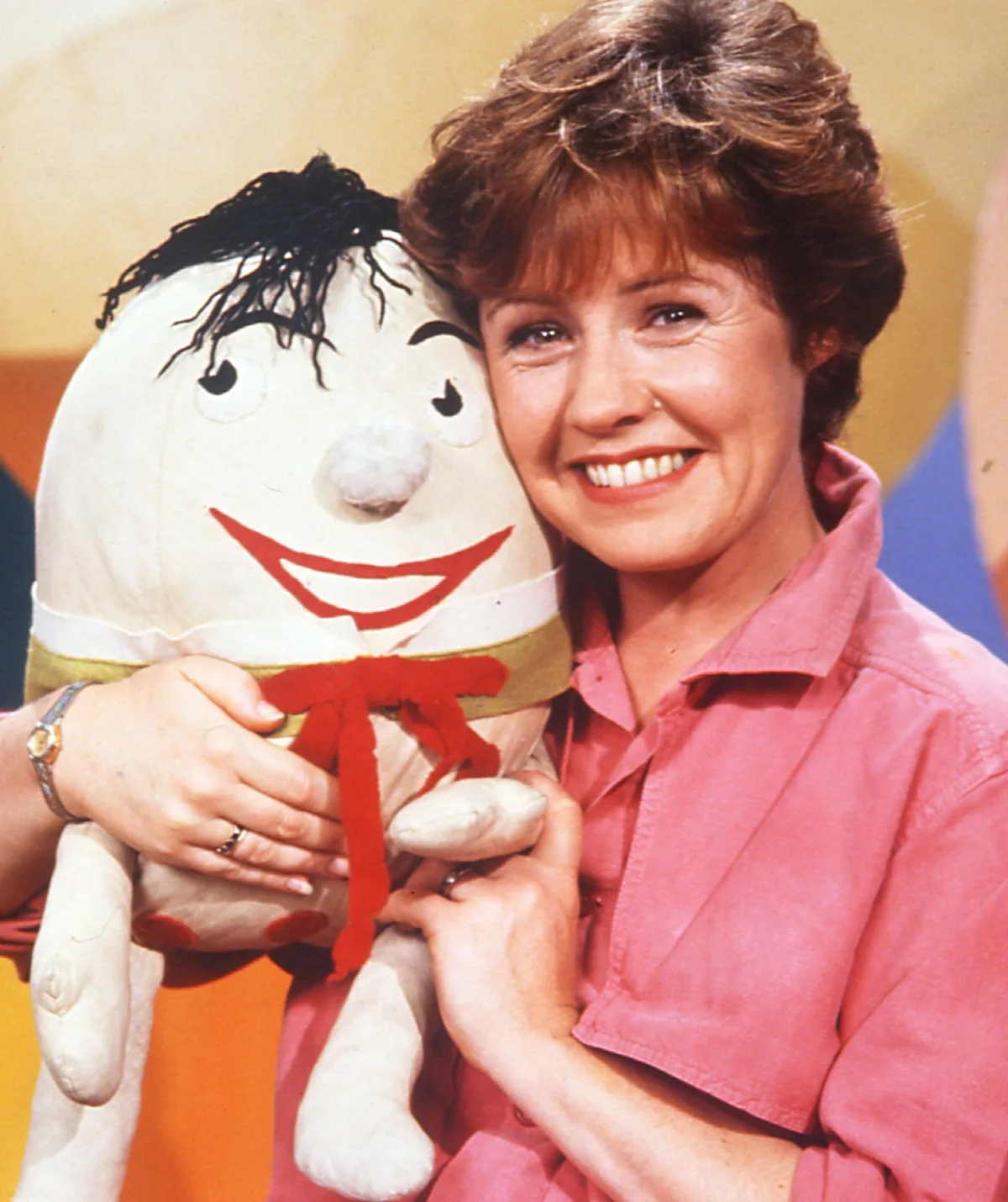 Noni Hazlehurst is holding Humpty Dumpty and smiling.