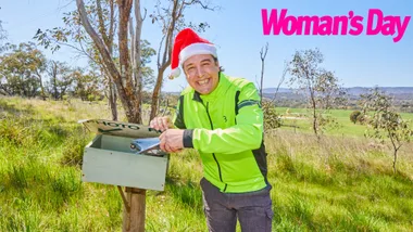 Samuel Johnson in a Santa hat at a mailbox