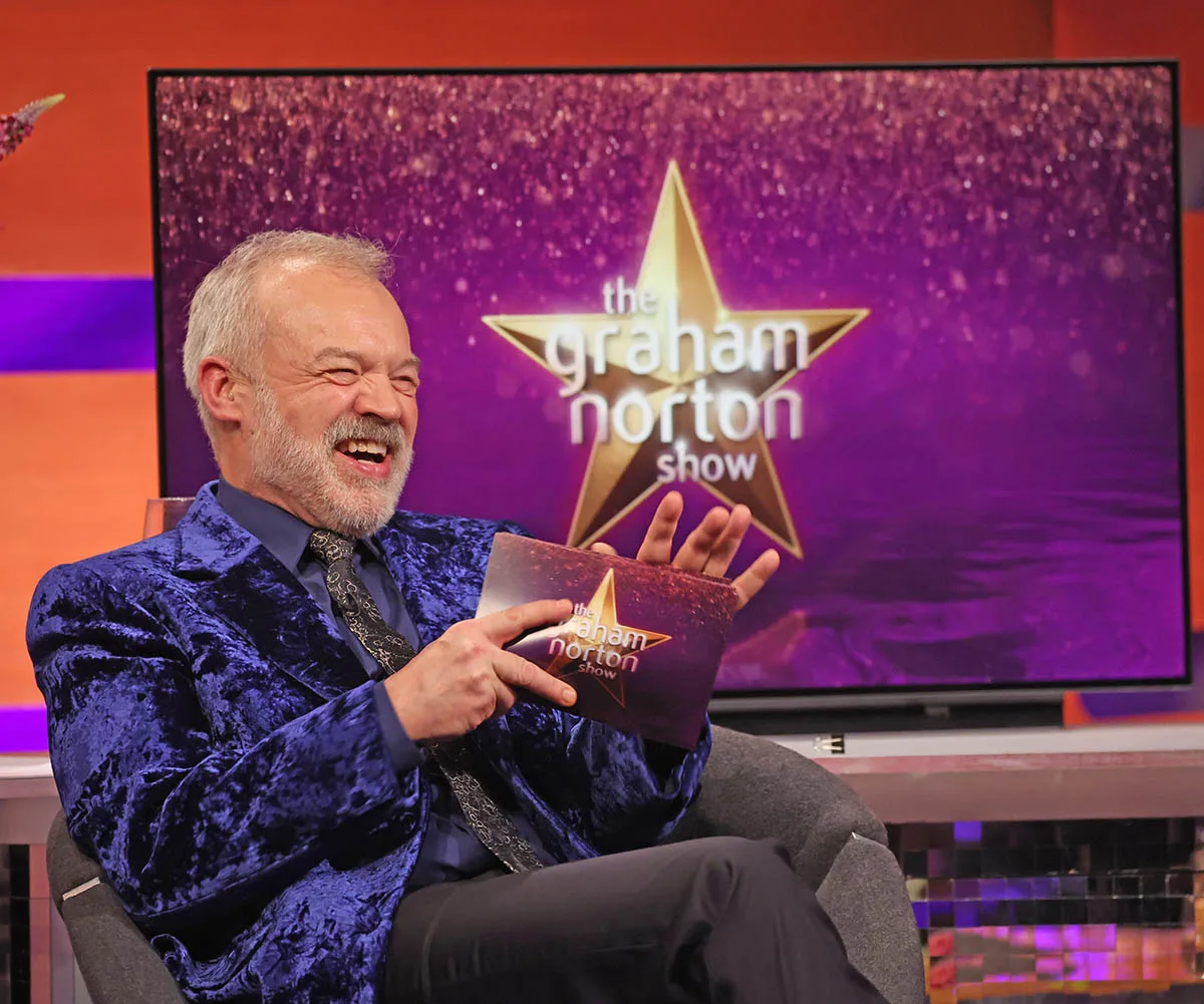 Graham Norton sitting on the set of his chat show.