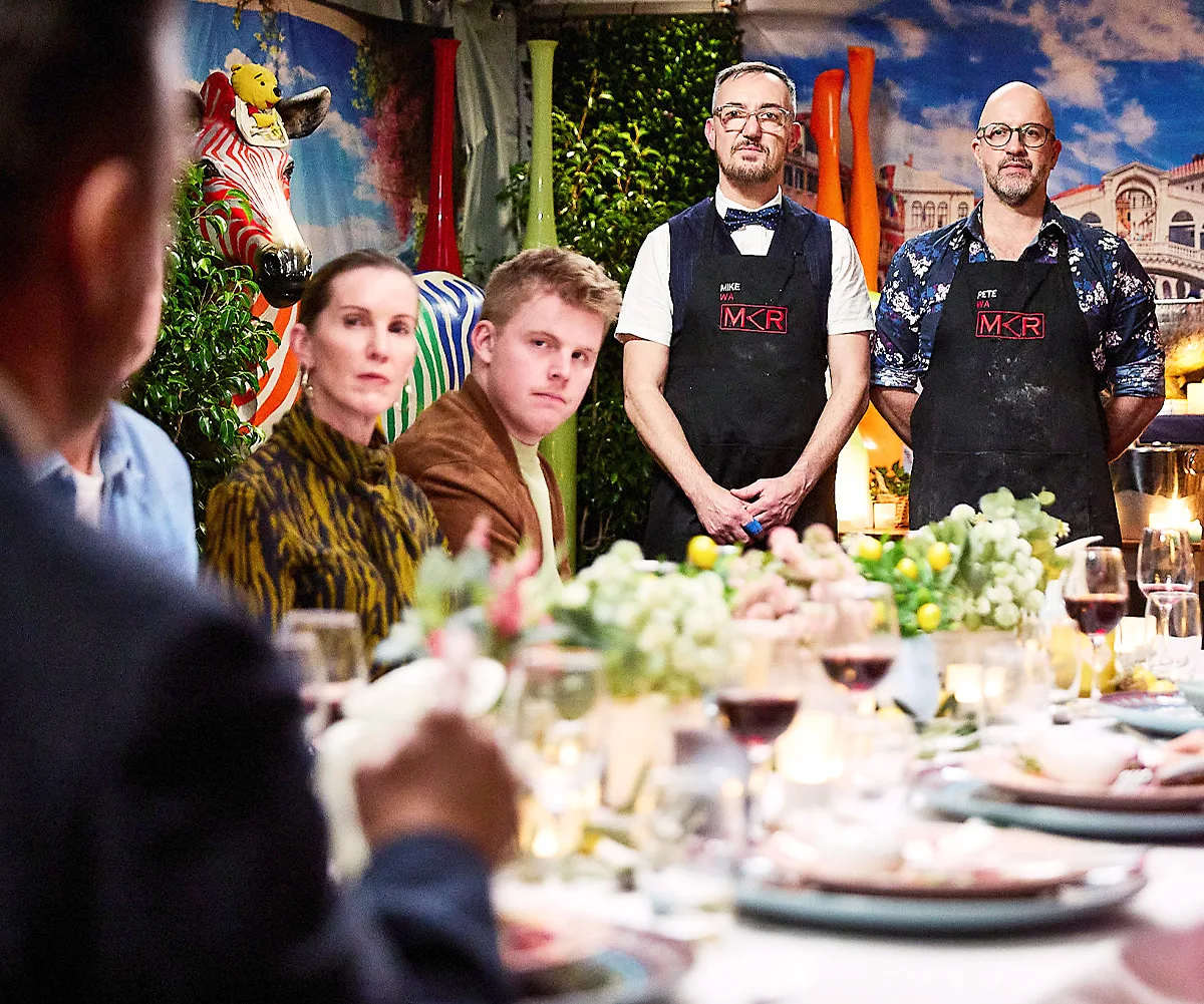 Mike and Pete stand at the end of the table at their instant restaurant.