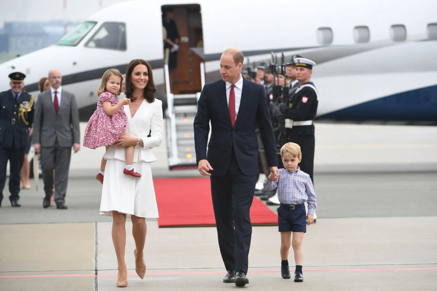 Kate Middleton holding Princess Charlotte and Prince Will holding George's hand 