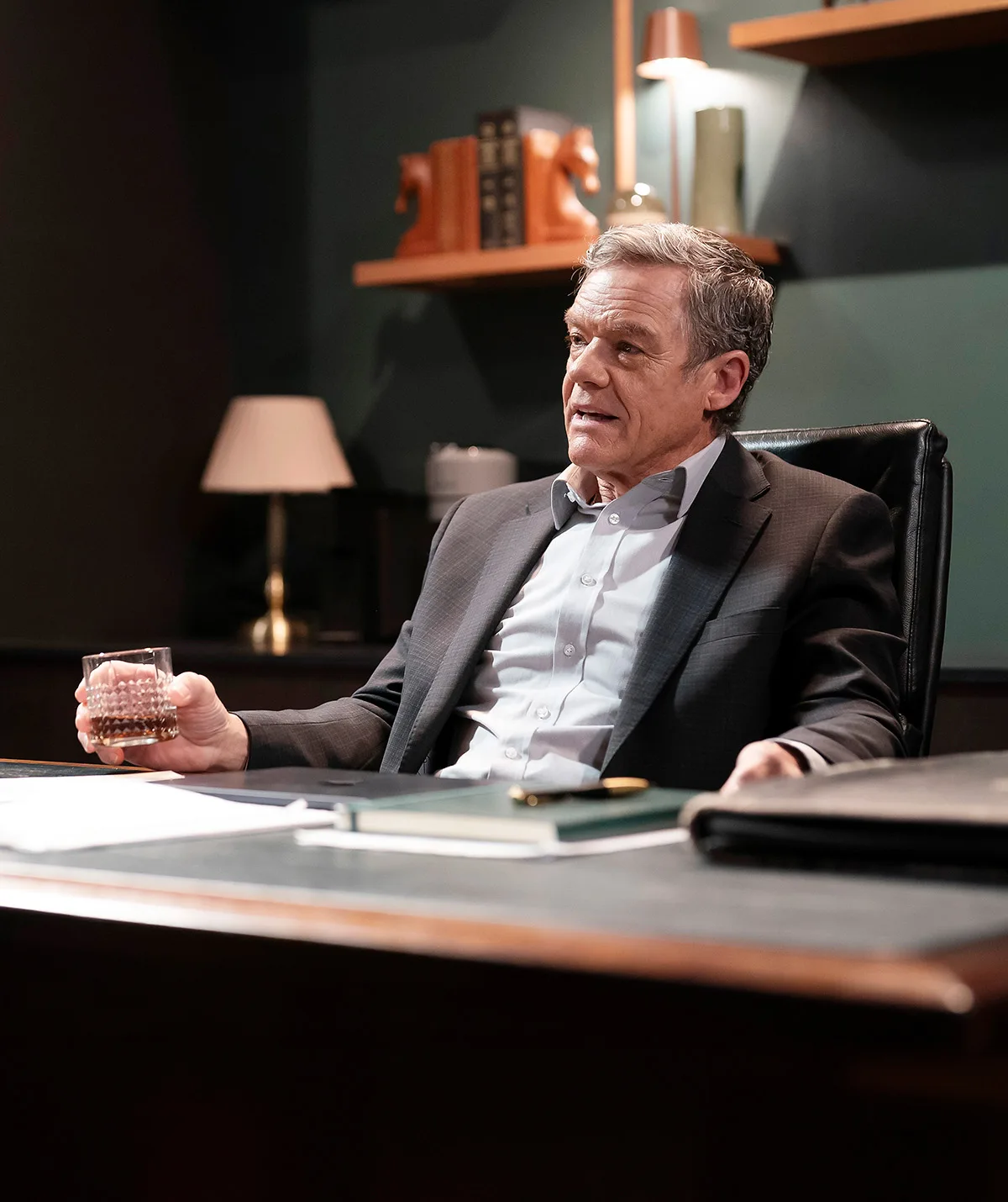 Stefan Dennis, as Paul Robinson, sits at his desk.