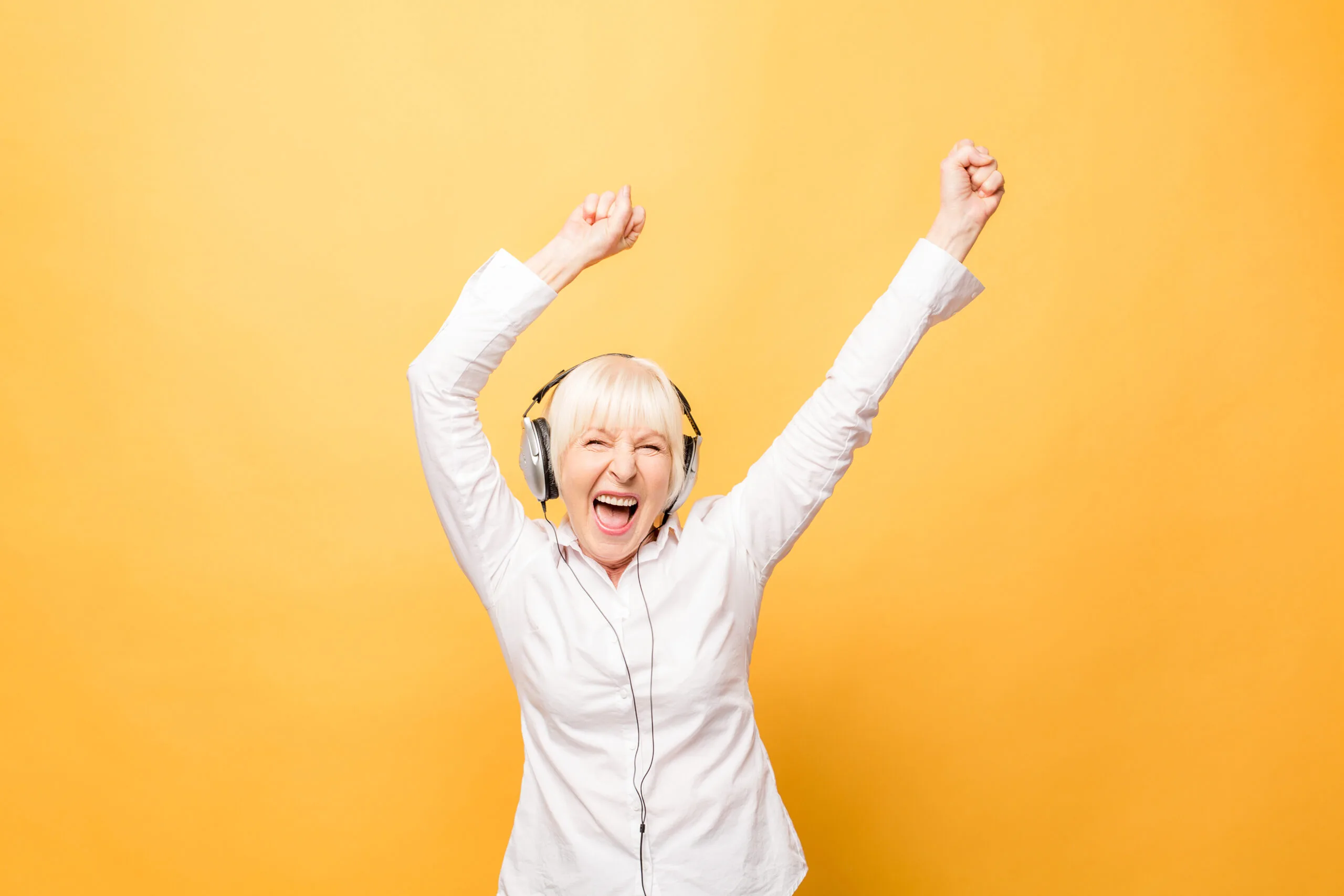 Extremely happy woman waving her arms in the arms dancing and listening to music