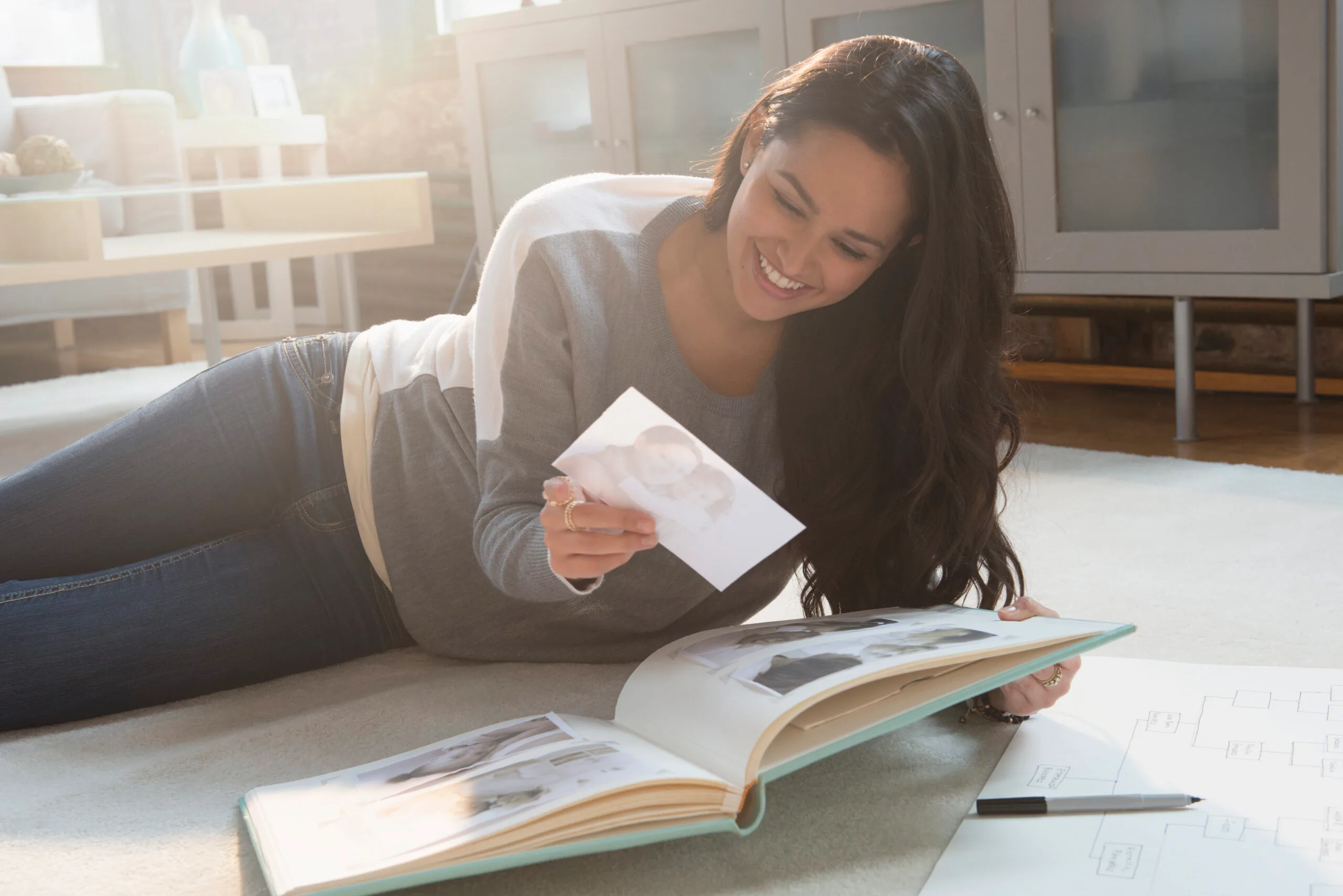 Happy woman looking at nostalgic photos - proven to boost your mood 