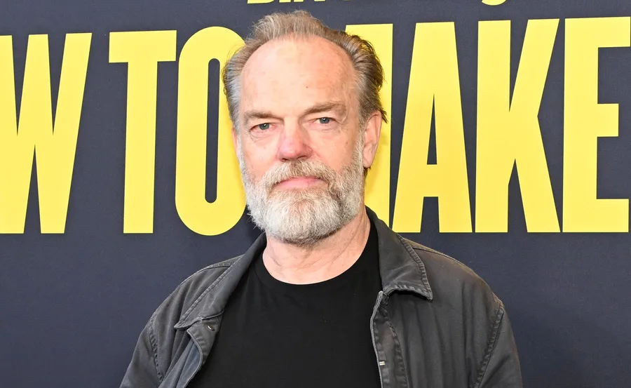 Hugo poses in a dark shirt on the red carpet of his new film How To Make Gravy