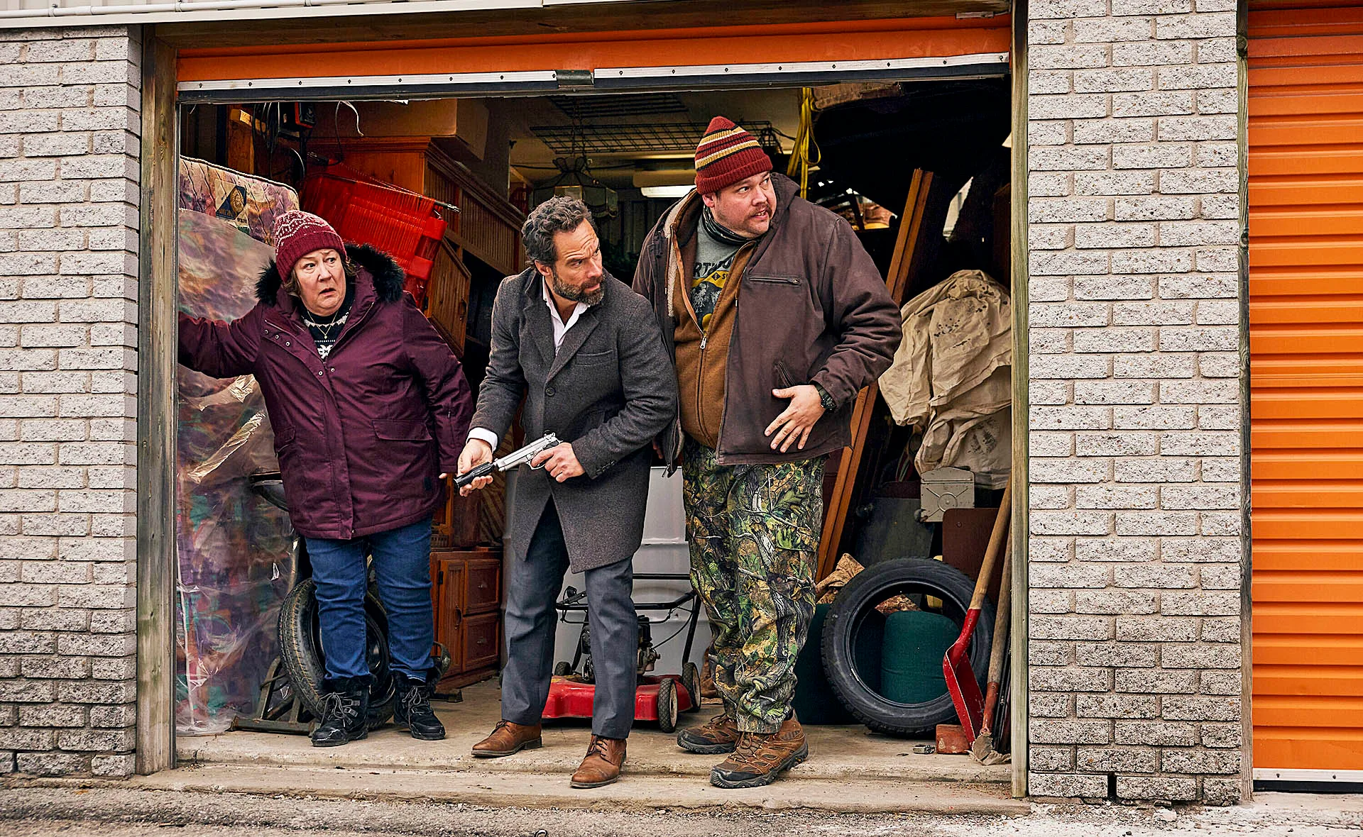 Margo Martindale as Ruth Landry, Chris Diamantopoulos as Mike Byrne and Guillaume Cyr as Remy Bouchard stand on the set of The Sticky, looking anxious. 