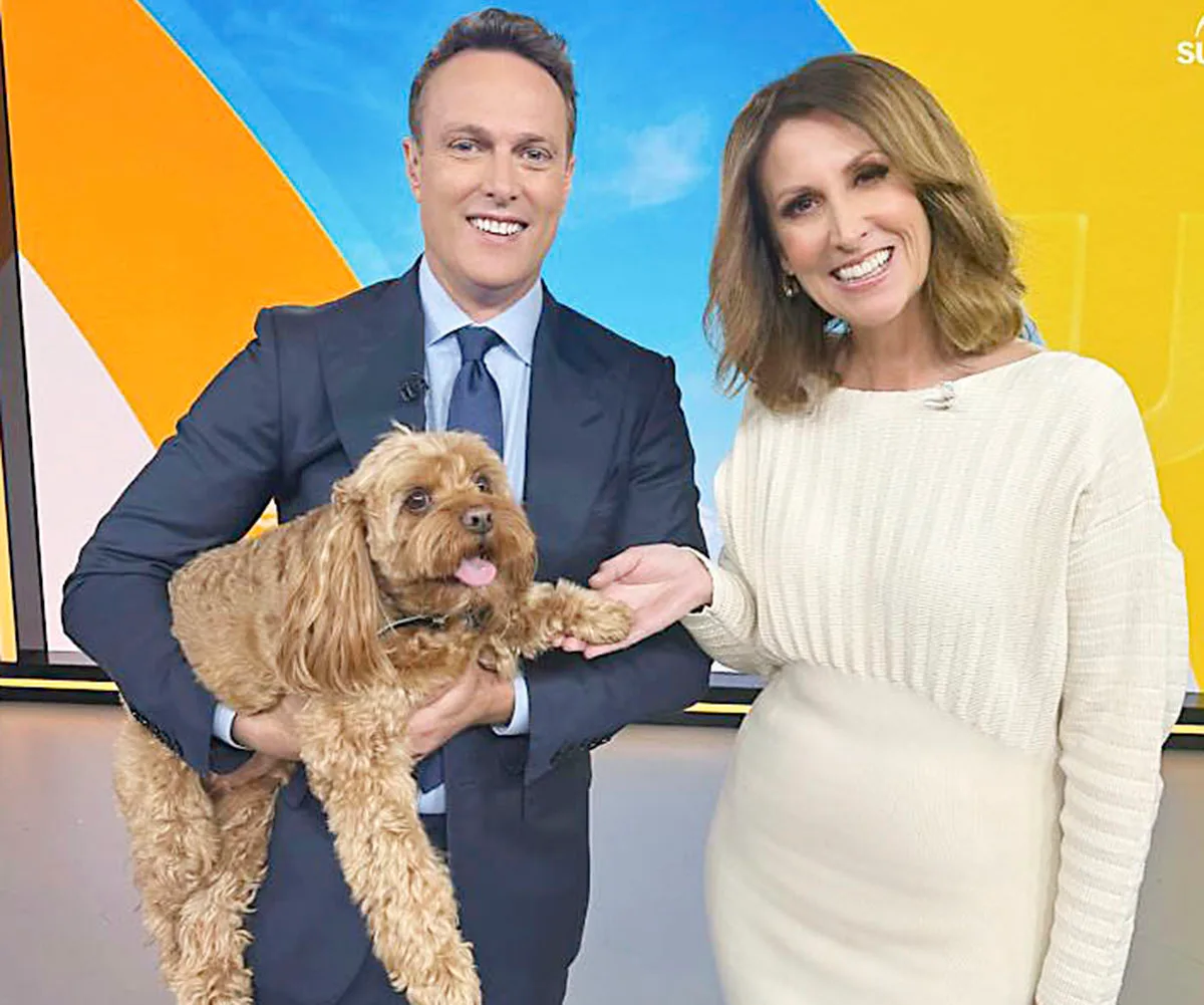 Matt Shirvington holds his cavoodle, Murphy, while standing next to Natalie Barr on the set of Sunrise.