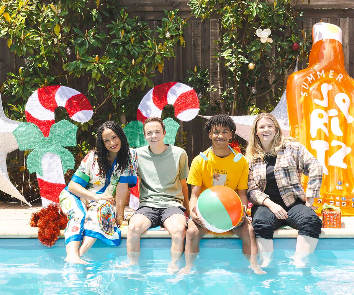 Naomi Rukavina, Riley Bryant, Marley Williams and Sara West on set of the Neighbours Christmas shoot. Sitting with legs in the pool holding pool toys with blow up candy canes behind them. 