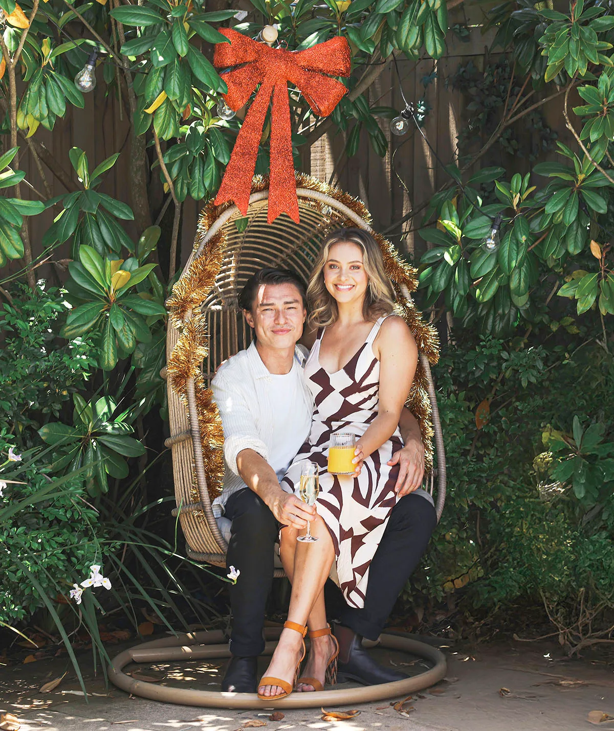 Majella Davis sitting on Tim Kano's lap in a Christmas chair with a green backdrop