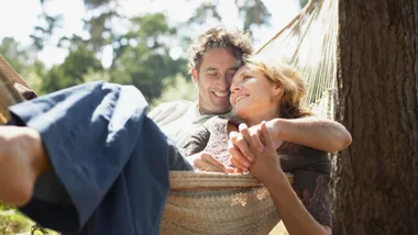 a happy couple sitting in a hammock