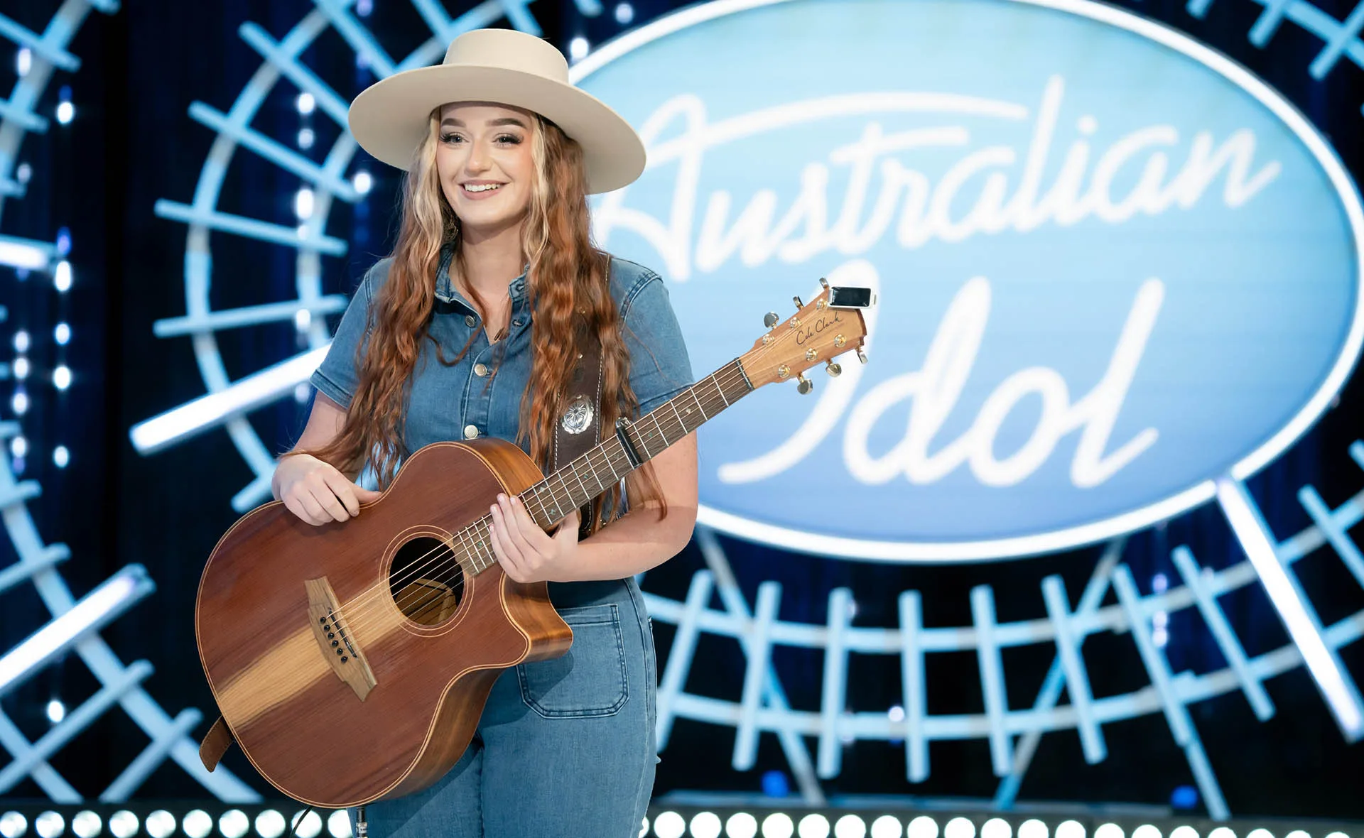 Singer Keely Ellen, wearing a hat and holding a guitar, auditions for Australian Idol